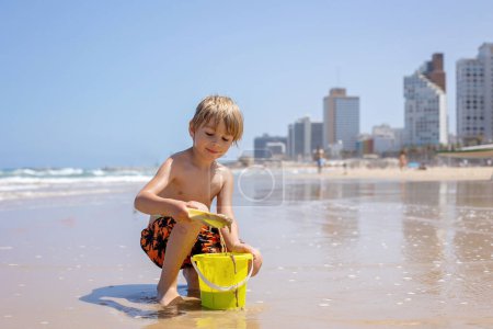 Photo for Child, boy, playing on the beach in Tel Aviv in the evening, summertime - Royalty Free Image