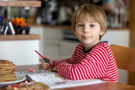 Photo for Child, school boy, writing homework at home after school in the afternoon - Royalty Free Image
