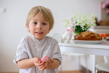 Foto de Niños, hermanos varones, huevos para colorear para Pascua en casa - Imagen libre de derechos