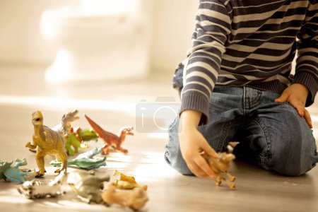 Foto de Pequeño niño pequeño, niño, mear en sus pantalones mientras juega con juguetes, niño distraído y se olvida de ir al baño en casa - Imagen libre de derechos