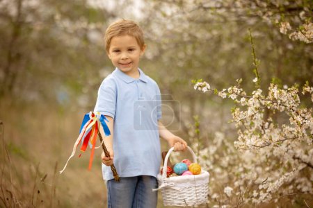 Photo for Cute preschool child, whipping his sister on Easter with twig, braided whip made from pussy willow, traditional symbol of Czech Easter used for whipping girls and women - Royalty Free Image