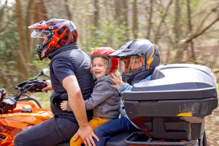Téléchargez les photos : Enfants, chevauchant sur une roue buggy avec père, voitures rapides, portant des casques - en image libre de droit