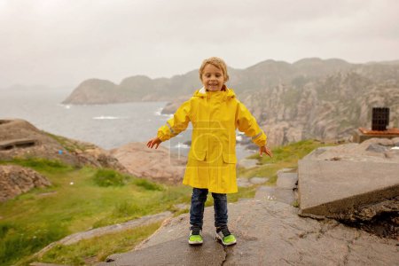 Family with children, visiting the Lindesnes Fyr Lighthouse in Norway on a rainy cold day