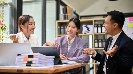 Photo for Happy and professional millennial Asian businesspeople or accountants enjoy working together in the office, meeting, discussing, and brainstorming. - Royalty Free Image