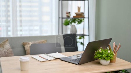 Photo for Modern urban office workspace with laptop computer, stationery, a cup of coffee and decor on the table. - Royalty Free Image