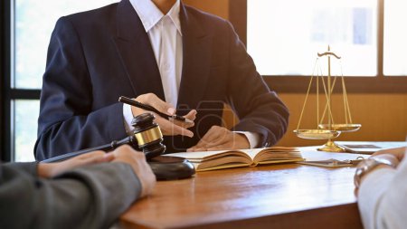 Ein professioneller männlicher Anwalt in einem formellen Anzug berät und berät seinen Mandanten im Büro. Nahaufnahme