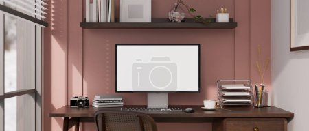 Foto de Diseño interior de oficina en casa rosa de moda con maqueta de pantalla blanca de computadora y decoración en la mesa de madera contra la pared rosa. Sala de trabajo femenina en casa. 3d render, ilustración 3d - Imagen libre de derechos