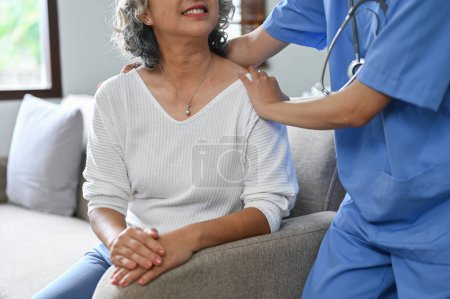 Foto de Imagen recortada, Una cuidadora o enfermera que visita a una anciana enferma de 60 años se retira en casa. - Imagen libre de derechos