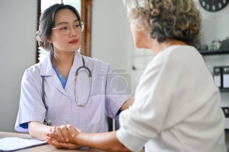 Foto de Doctora asiática joven profesional y enfocada que habla y explica el tratamiento médico para jubilar a la paciente femenina en el consultorio del hospital. - Imagen libre de derechos