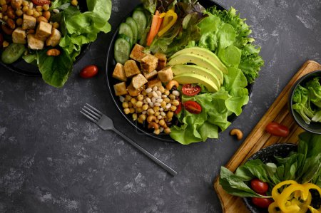 Photo for Tasty and healthy plant based or vegan food meal on stylish dark background. Grilled tofu with high nutrition vegetables and nuts. top view - Royalty Free Image