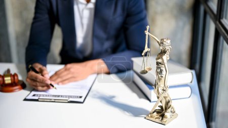 Photo for Professional Asian male lawyer or legal consultant examining contract agreement paper, working at his desk. cropped image - Royalty Free Image