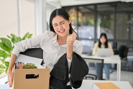 Foto de Happy and excited young Asian female office worker celebrating her resignation, carrying her personal stuff. leaving job, changing job position or company. - Imagen libre de derechos