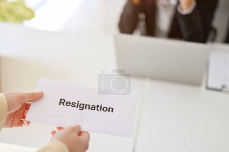 Photo for A businesswoman or female office worker handing her resignation latter to her boss in the office. close-up image - Royalty Free Image