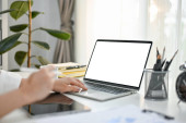Close-up side view image of a businesswoman using her laptop at her desk in modern bright office. laptop blank screen mockup for display your graphic ads. t-shirt #644847306