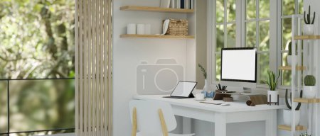Foto de Diseño interior moderno del espacio de trabajo del hogar blanco con PC computadora de escritorio y tableta pantalla en blanco maqueta en la mesa, estante de cactus, silla y decoración. 3d render, ilustración 3d - Imagen libre de derechos