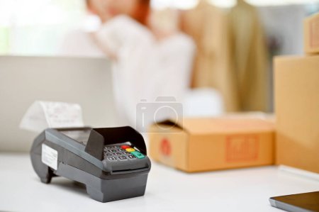 Image en gros plan d'un lecteur de carte ou d'un terminal PDV sur une table. NFC payment technology, cash-less society, electronic payment.