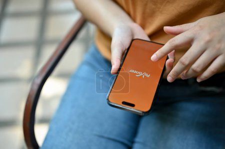 Photo for Chiang Mai, Thailand - May 26 2023: Close-up image of a female using Payoneer app on her iPhone. - Royalty Free Image
