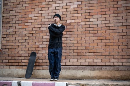 Un fresco, profesional asiático masculino b-boy breakdancer en ropa de moda está bailando en el sendero, realizando su breakdance en la calle al aire libre.