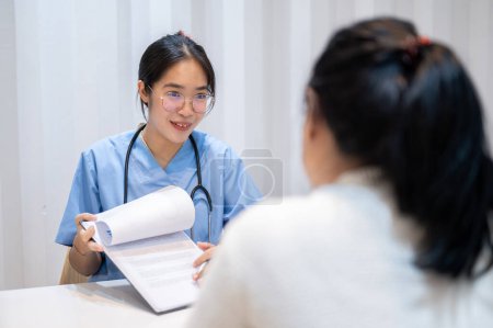 Photo for A professional and experienced Asian female doctor showing reports and giving advice to a patient during a medical check-up at the hospital. People and healthcare concepts - Royalty Free Image