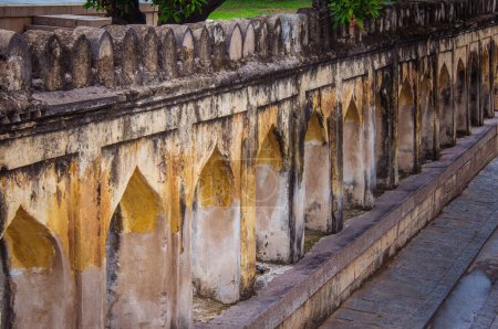 Foto de Corredor entre las estructuras de la tumba y el jardín ajardinado en Qutb Shahi Archaeological Park, Hyderabad, India - Imagen libre de derechos