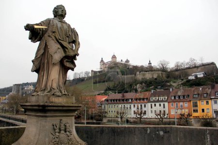 Photo for St. Colman statue on the Old Main Bridge, Alte Mainbruecke, Marienberg Fortress on a hill in the background, Wurzburg, Germany - January 26, 2023 - Royalty Free Image