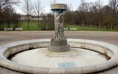 Photo for Fountain of Knowledge in the Chestnut Roundel in Kurpark, Jugendstil sculpture of Adam and Eve in the Garden of Eden, view on cloudy snowless winter afternoon, Bad Nauheim, Germany  - January 29, 2023 - Royalty Free Image
