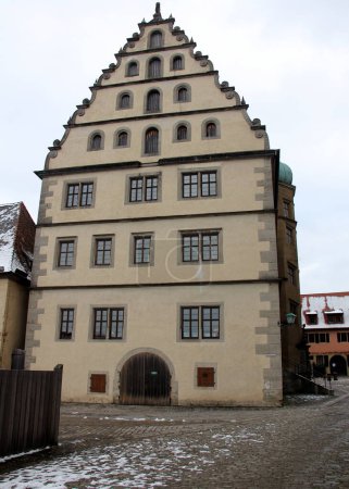 Photo for Renaissance building of the Old Gymnasium, at Kirchplatz 13, built in 1589, side elevation with the stepped gable of the roof, Rothenburg ob der Tauber, Germany - February 6, 2023 - Royalty Free Image