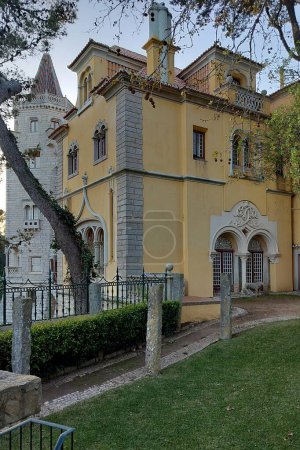 Palace of Counts of Castro Guimaraes, built in 1900 in eclectic architectural style as an aristocrats summer residence, garden side entrance in sunset light and shadows, Cascais, Portugal - March 5, 2024