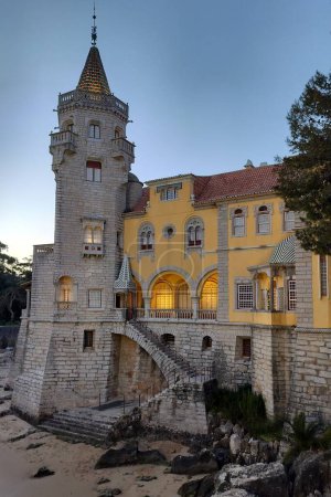 Palace of Counts of Castro Guimaraes, built in 1900 in eclectic architectural style as an aristocrats summer residence, in evening illumination, Cascais, Portugal - March 5, 2024