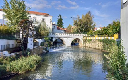 Fluss Almonda, der durch den Dukes Mill Park fließt, mit hölzernem Wassermühlenrad, in der Altstadt, Torres Novas, Portugal - 25. November 2023