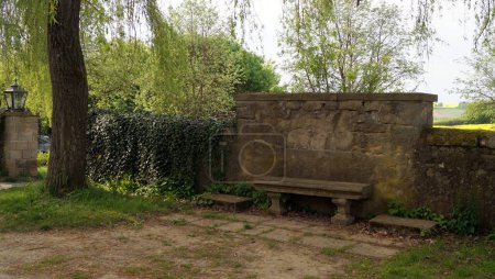 Banco de piedra junto a la valla del parque en Fasanerie Castle, vista al atardecer, Eichenzell, cerca de Fulda, Alemania - 10 de mayo de 2022