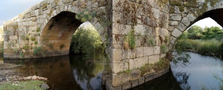 Stone arches of the Old Bridge, Ponte Velha, Roman and medieval bridge across the Ponsul River, Idanha-a-Velha, Portugal - May 18, 2023