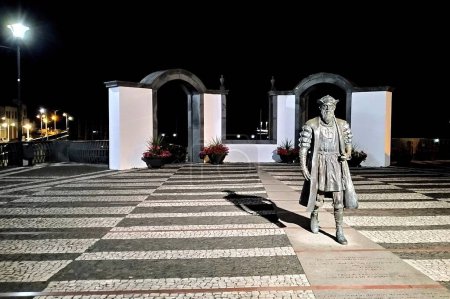 Foto de Estatua de Vasco da Gama, explorador portugués y almirante de la Edad de los Descubrimientos, instalada en la fachada del puerto, vista nocturna, Angra do Heroismo, Terceira, Azores, Portugal - 28 de julio de 2022 - Imagen libre de derechos