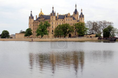 Schweriner Schloss am See spiegelt sich an einem bewölkten Tag im Wasser, Schwerin, Deutschland - 3. Mai 2012
