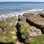 Coastal volcanic boulder formations at the water s edge on the beach, Praia do Pescoco do Cavalo, Estoril, Portugal - May 18, 2024
