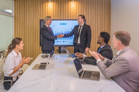 Téléchargez les photos : Homme d'affaires diversifié ayant poignée de main ensemble après négociation d'accord d'affaires dans la salle de réunion - en image libre de droit