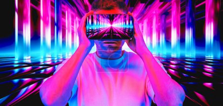 A man is immersed in the vibrant neon-lit cyber world of the metaverse, experiencing it firsthand through his VR headset