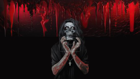 Halloween concept of spooky bloody demon with skull face portrait with cross necklace hanging on hands in bloody dark hell background