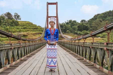 Foto de Joven mujer Rawang en vestido tradicional Rawang en el puente Kaungmulone sobre el río Mali Kha, Putao, estado de Kachin, Myanmar - Imagen libre de derechos