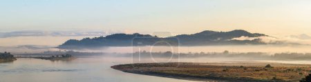 Photo for The serene morning haze settles over the Irrawaddy River, framing the Bala Min Htin Bridge in Myitkyina, Myanmar, a blend of nature's tranquility and human ingenuity - Royalty Free Image