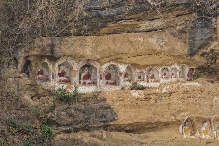 Téléchargez les photos : Des statues antiques de Bouddha émergent de la falaise d'Akauk Taung, Pyay, offrant un aperçu de l'art spirituel du Myanmar - en image libre de droit