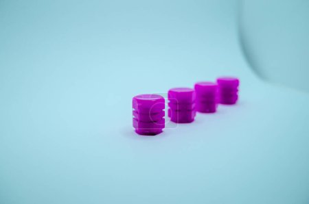 Téléchargez les photos : Quatre bouchons de valve de pneu violet sur fond blanc - en image libre de droit