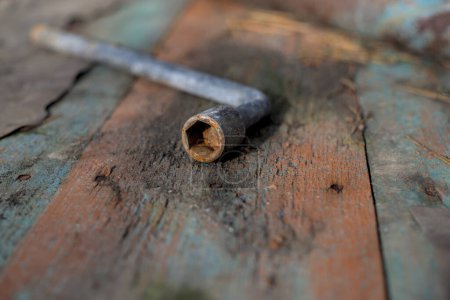 Llave oxidada vieja aislada en la madera