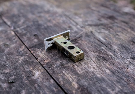 Photo of used door latch on the wood