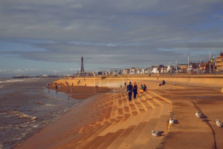 Téléchargez les photos : People walk along Blackpool promenade in England - en image libre de droit