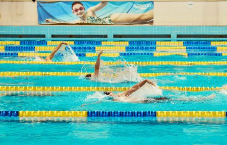 Foto de Kiev, Ucrania, 10.28.2023. Competición de natación en el complejo deportivo CSK ZSU. Carriles de la piscina turquesa, un símbolo del deporte y los Juegos Olímpicos. Estilo de espalda. - Imagen libre de derechos