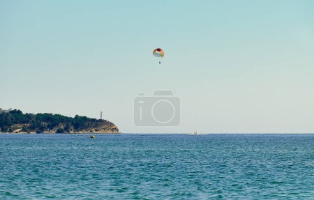 Couple is parasailing in the blue sky. Summer vacation on the Black Sea.