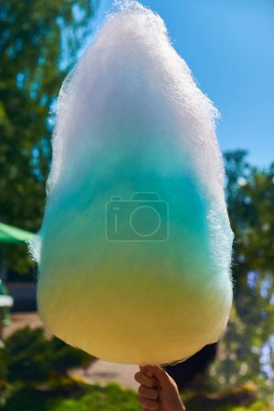 Sweet and colorful cotton candy in hand. The image exudes a sense of nostalgia and childlike wonder.
