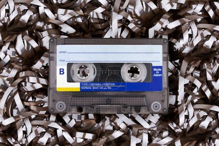 Retro cassette tape on textured brown magnetic tape surface.