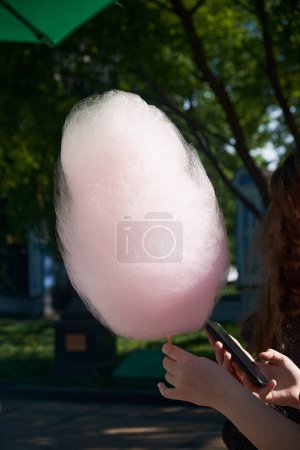 Photo for Sweet and colorful cotton candy in hand. The image exudes a sense of nostalgia and childlike wonder. - Royalty Free Image